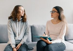 female therapist engaging in bipolar disorder treatment with teenage girl
