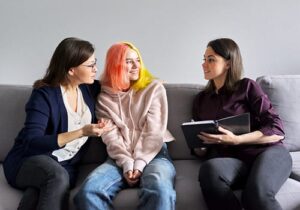 therapist talking to mother and daughter about a family therapy program